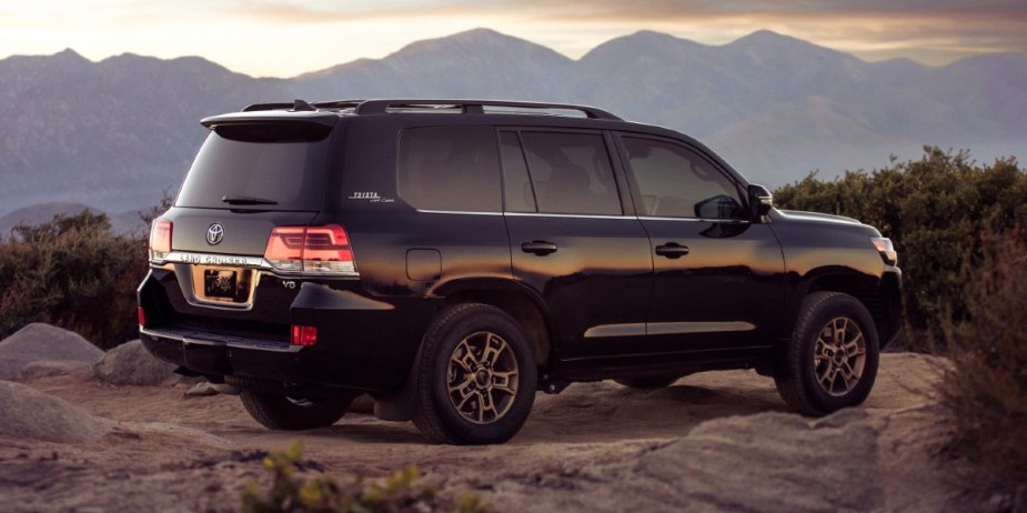 A black 2021 Toyota Land Cruiser full-size SUV is parked off-road. 