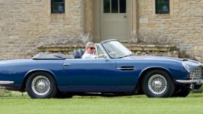 King Charles in blue vintage Aston Martin