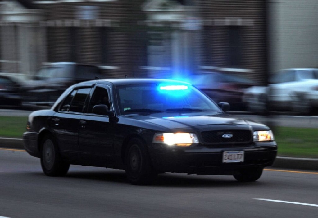 A Ford Crown Victoria unmarked police car moves to the scene of a crime or broken law.