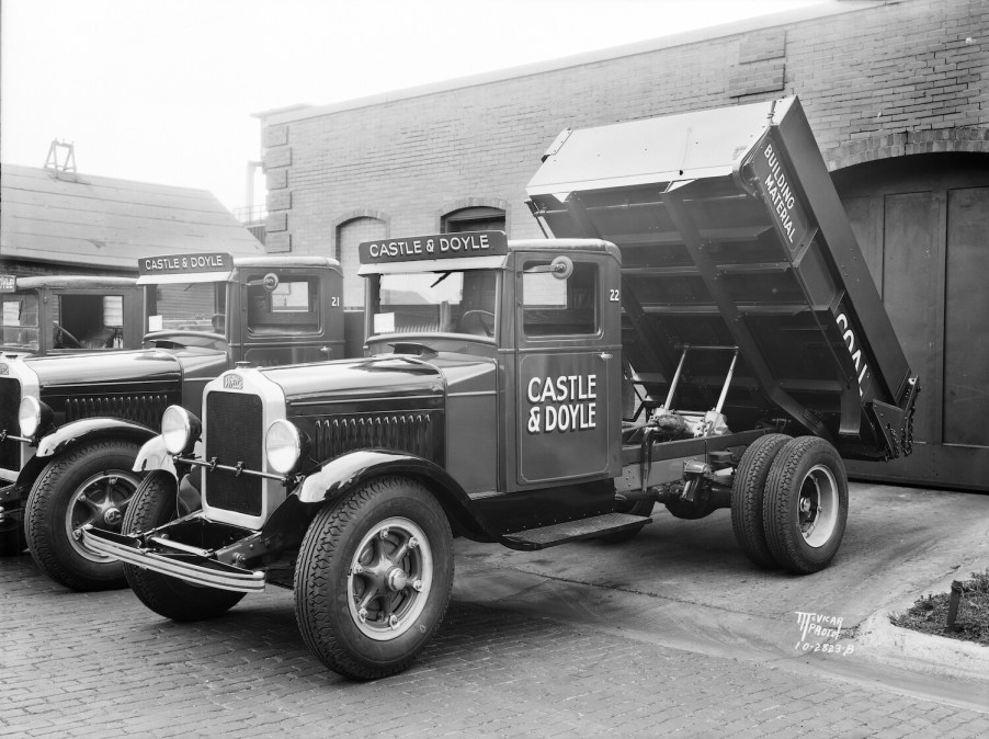 A White brand truck with its dump bed activated.