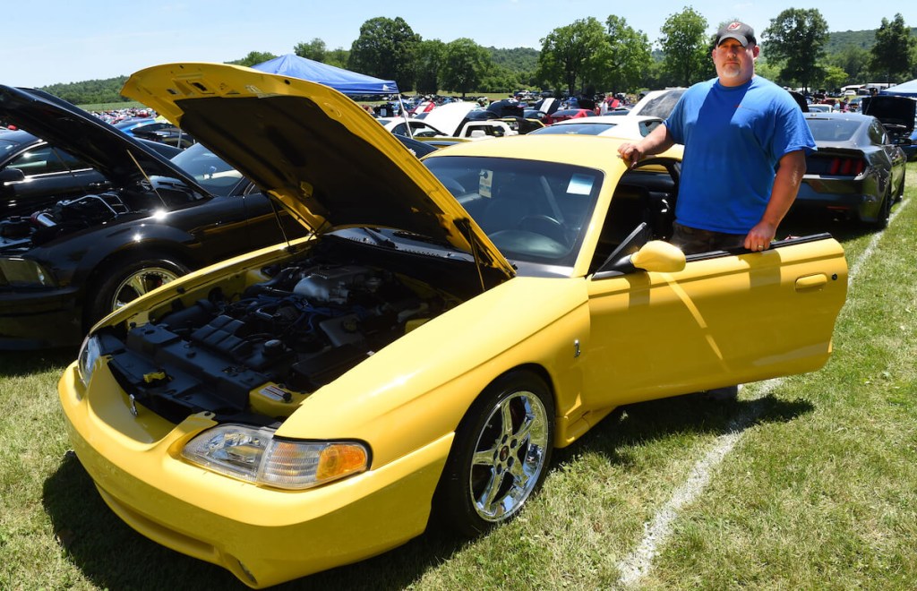 A Yellow Ford Mustang Cobra parked at a car show