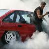 A car enthusiast does a burnout in an old Ford Focus