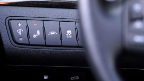 Driver assistance buttons next to the steering wheel, including Lane Departure Warning, in a 2014 Kia Cadenza