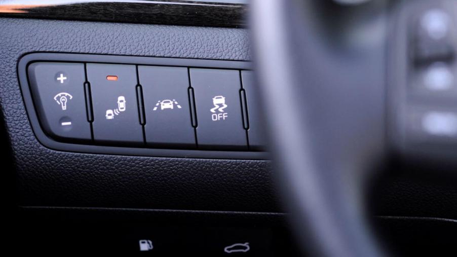 Driver assistance buttons next to the steering wheel, including Lane Departure Warning, in a 2014 Kia Cadenza