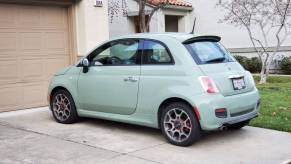 A mint green Fiat 500 model parked on a driveway outside a suburban home garage in San Ramon, California