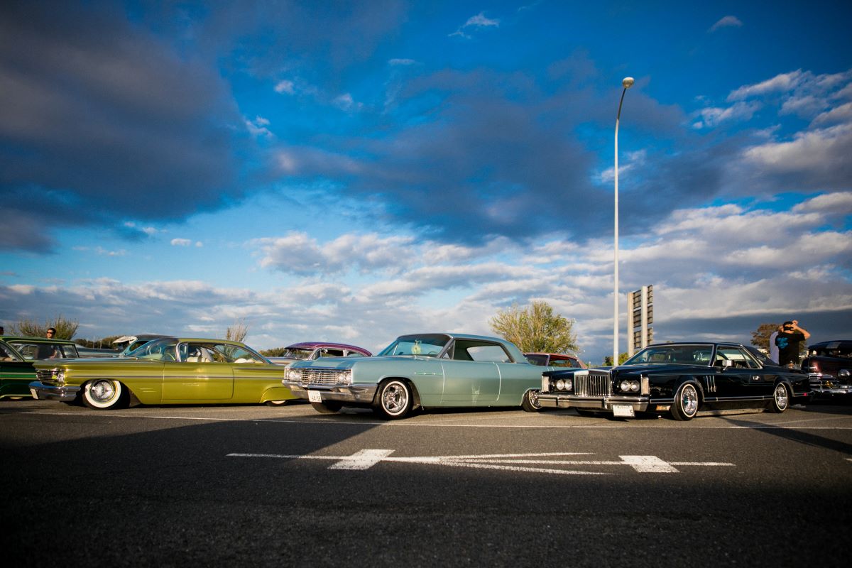 A lineup of different colored lowriders from the Pharoahs parked on the Agui highway in Agui, Aichi, Japan