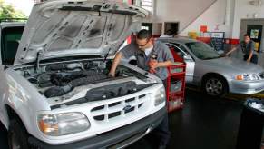 A mechanic performs an oil change service in a Ford vehicle at Jiffy Lube