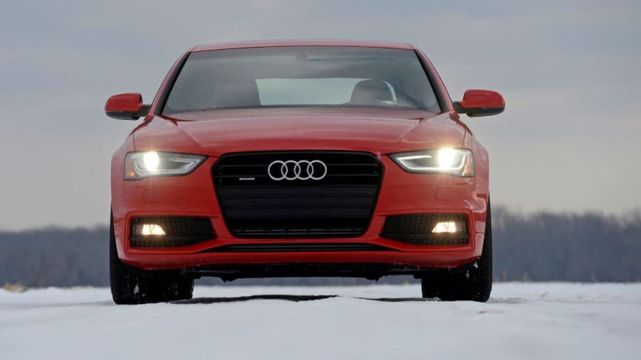 A red 2015 Audi A4 luxury compact executive car model driving on snow in Northampton, Massachusetts