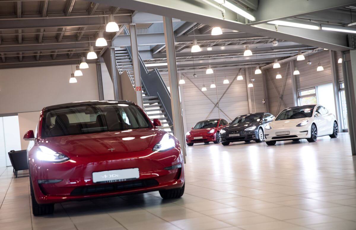 A red Tesla Model 3 vwith other Tesla models in the background at the Tesla Service Center in Hamburg, Germany