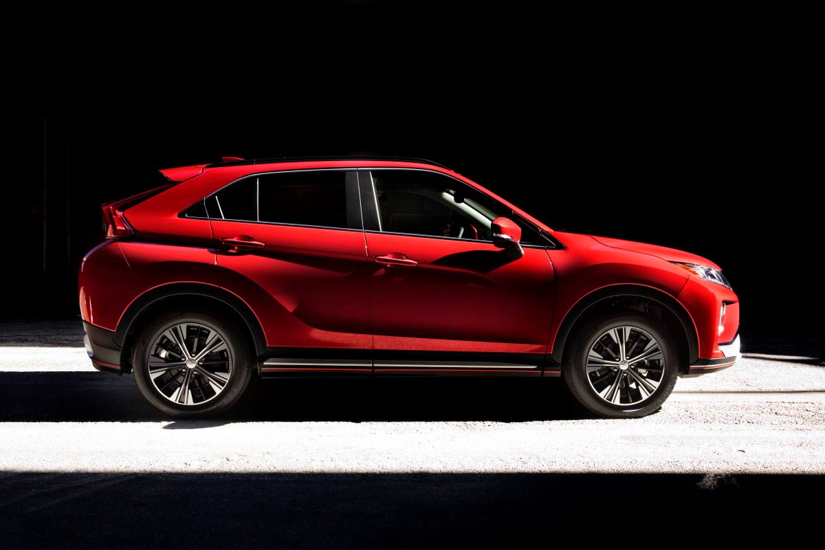 A side profile shot of a red 2019 Mitsubishi Eclipse Cross compact SUV model cloaked in shadows