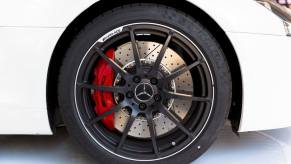 The wheel and ventilated disc brakes of a Mercedes AMG SLS 6.3 with red brake calipers