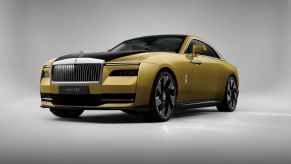 A yellow-gold Rolls-Royce Spectre ultra-luxury all-electric sports car souper coupe model