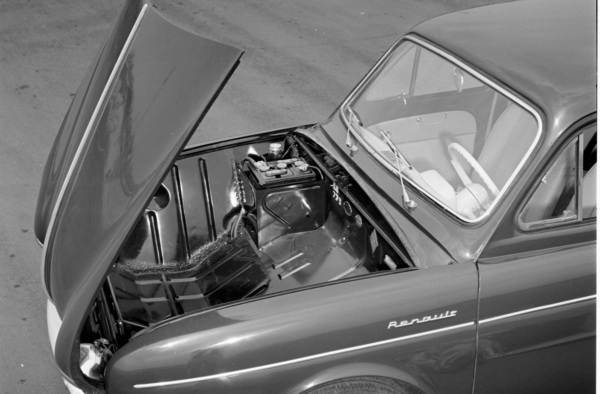 A black and white photo of an imported 1956 Renault Dauphine four-doo coupe model with a clamshell hood