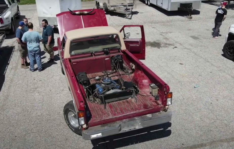 Bird's-eye view of the V8 engine in the bed of a modified 1985 Ford F-150 truck that drives backward.
