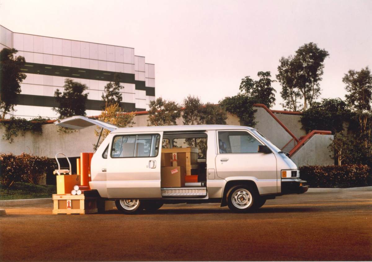 A retro looking Toyota van parked outside a building.