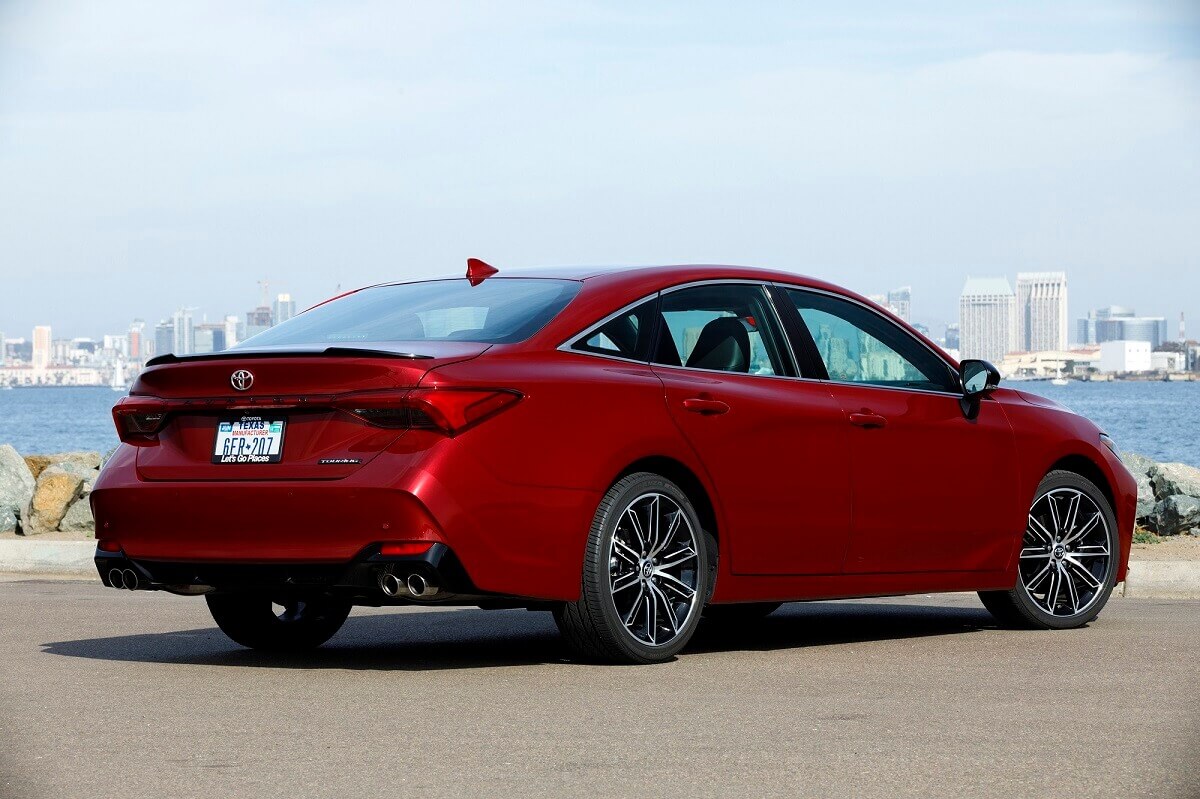 A 2022 Toyota Avalon shows off its rear-end styling next to a harbor.