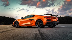 Orange 2023 Corvette on a road at sunset.