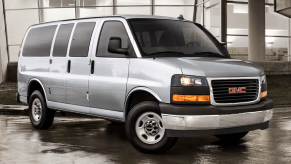 A 2023 GMC Savana full-size passenger van model parked on wet concrete