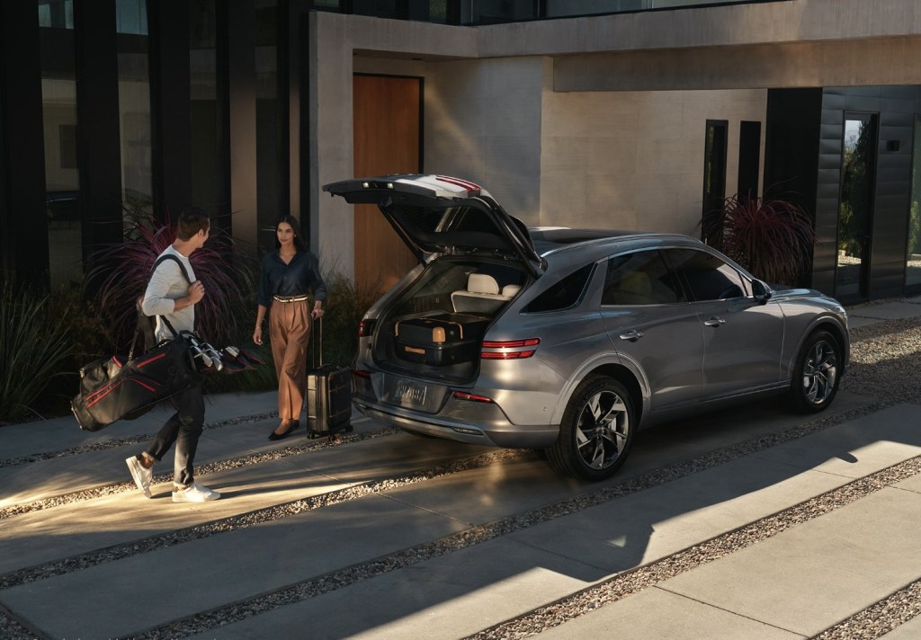 People loading luggage into the 2023 Genesis Electrified GV70