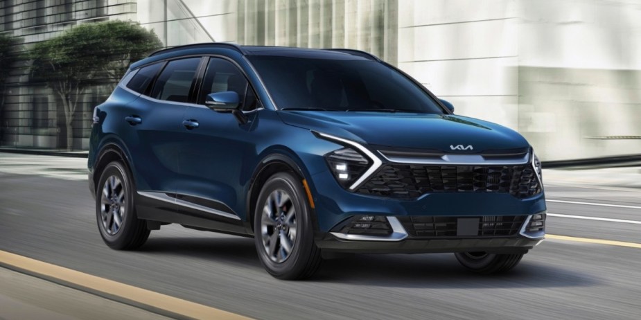 A blue 2023 Kia Sportage Hybrid is driving on the road, it's an excellent option in the states with the highest gas prices.