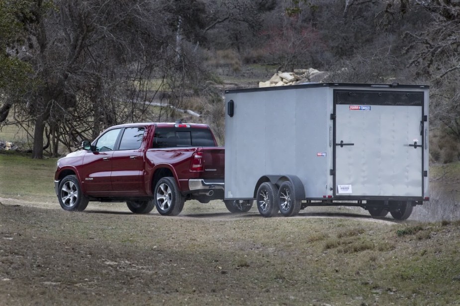 A dark red 2023 Ram 1500 towing a trailer. Does it tow better than a Toyota Tundra? 