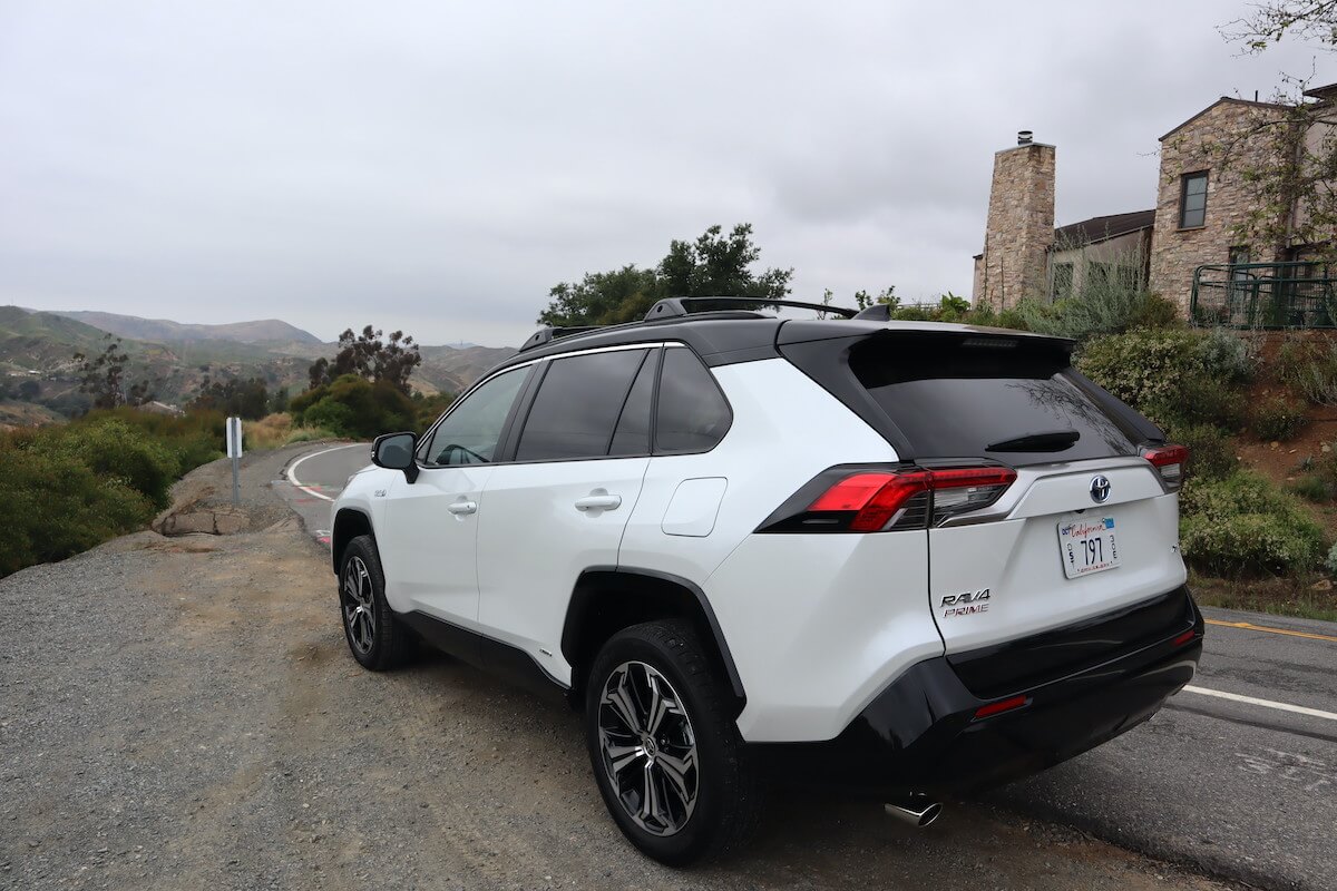 A 2023 Toyota RAV4 Prime rear view with a stone house in the background