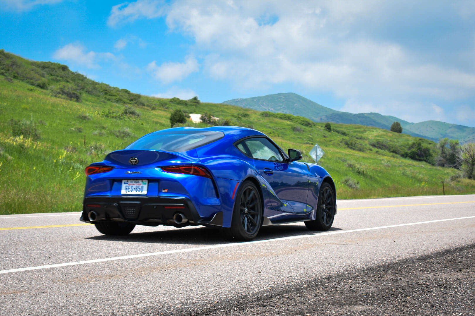 A rear view of the 2023 Toyota Supra driving by.