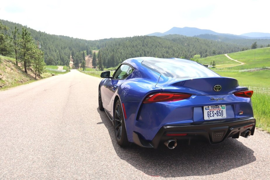 A rear view of the 2023 Toyota Supra parked on a road