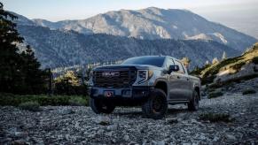 A 2024 GMC Sierra 1500 AT4X AEV Edition full-size pickup truck model parked on gravel in a forest mountain