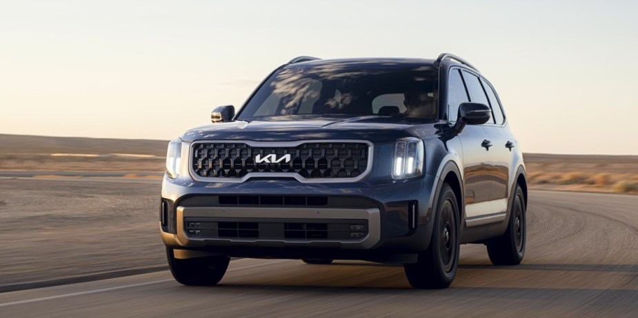 A blue 2024 Kia Telluride midsize three-row SUV is driving, its price, engine, and features are revealed.