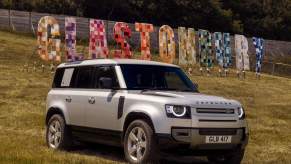A 2024 Land Rover Defender luxury SUV parked on a hill at the 2023 Glastonbury Festival
