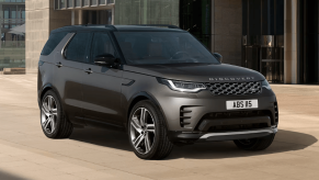 A 2024 Land Rover Discovery full-size luxury SUV model parked on a tan tile plaza