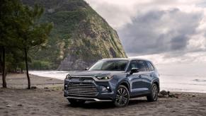 A 2024 Toyota Grand Highlander Platinum midsize SUV model in Storm Cloud coloring parked on a beach