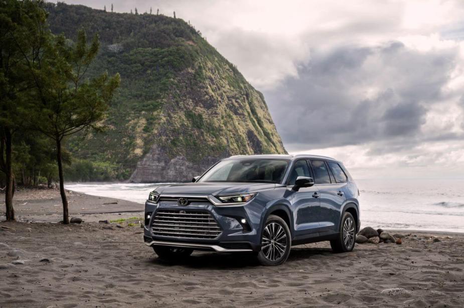A 2024 Toyota Grand Highlander Platinum midsize SUV model in Storm Cloud coloring parked on a beach