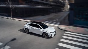 Overhead look at the white 2024 Lexus UX Hybrid on a city street.