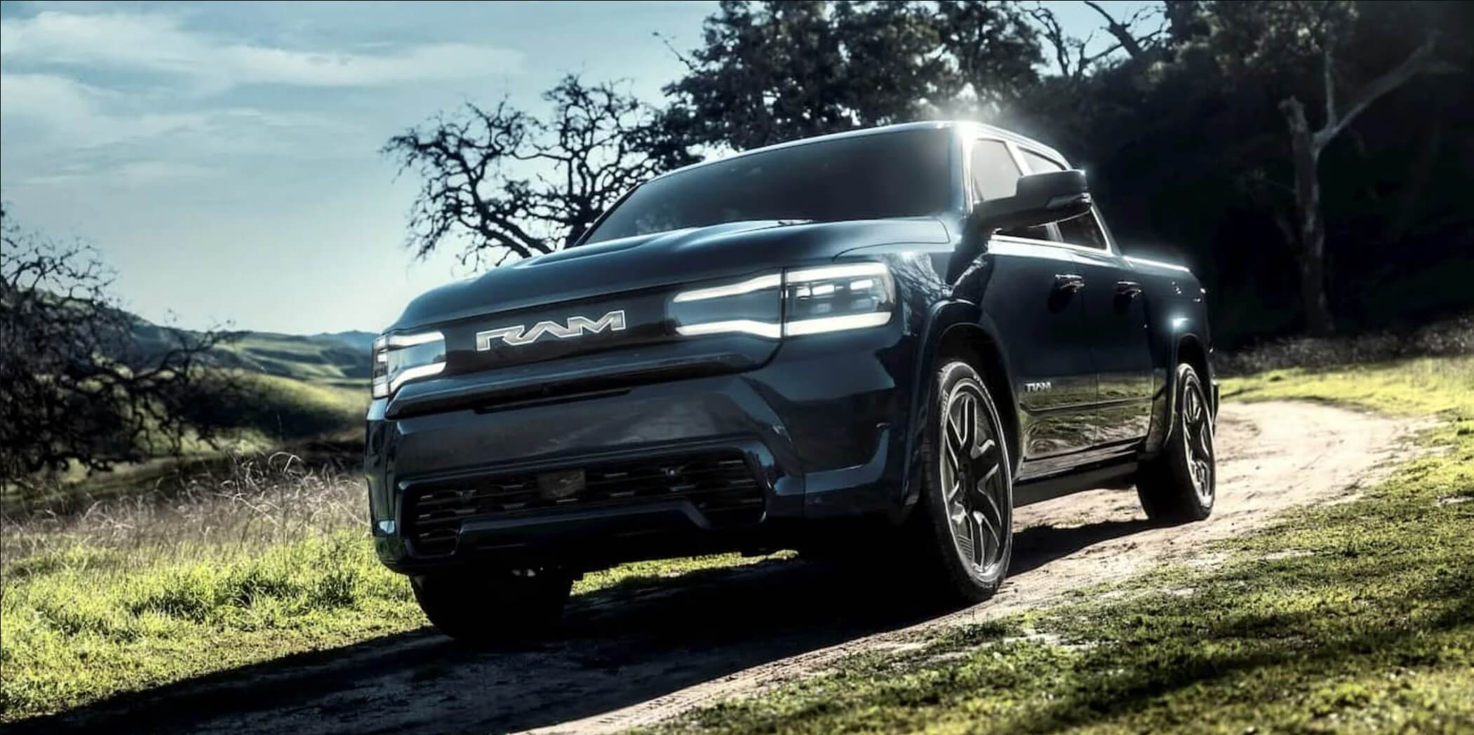 The 2025 Ram 1500 REV driving on a dirt road