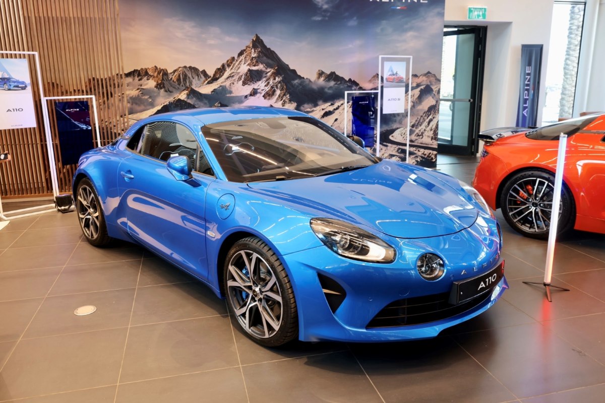 A blue Alpine A110 Sports Car parked in a showroom