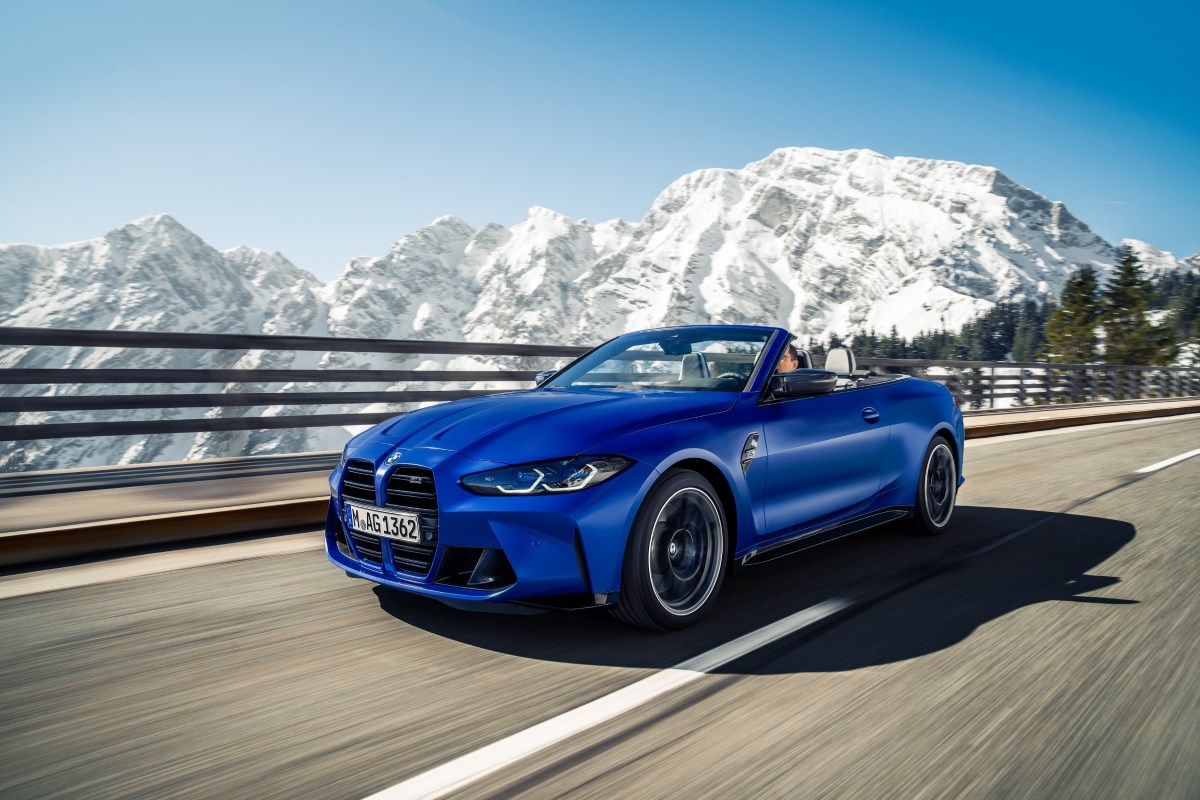 A blue 2023 BMW M4 Convertible with the mountains in the background