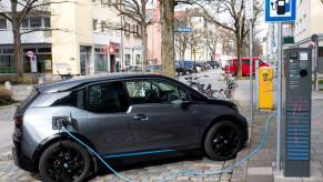 A BMW i3 electric car being charged at a charging station on a street in Bavaria, Forstinning, Germany