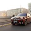 A BMW iX M60 midsize electric luxury SUV model in Aventurin Red Metallic