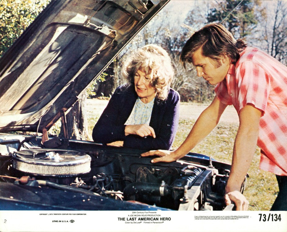 Geraldine Fitzgerald watches as Jeff Bridges looks under the hood of a car in a scene from the movie 'The Last American Hero', 1973.