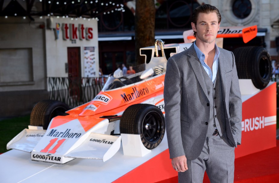 Actor Chris Hemsworth stands in front of James Hunt's F1 race car at the film premiere of his Rush movie.