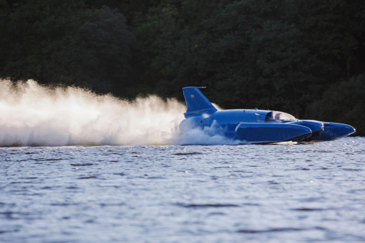 A blue speed boat racing across the water.