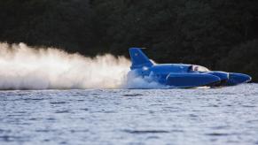 A blue speed boat racing across the water.