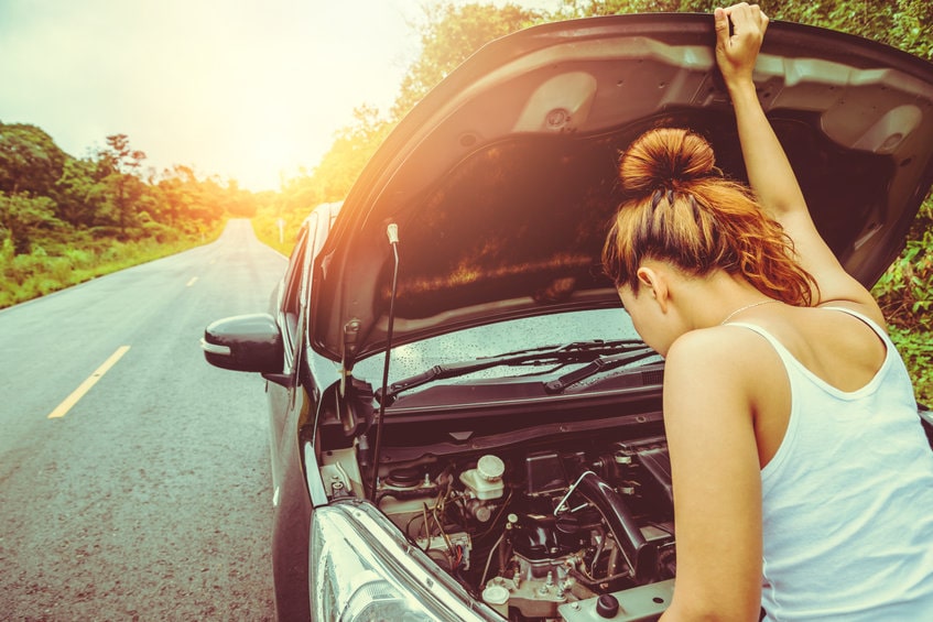 A woman checking her car engine 