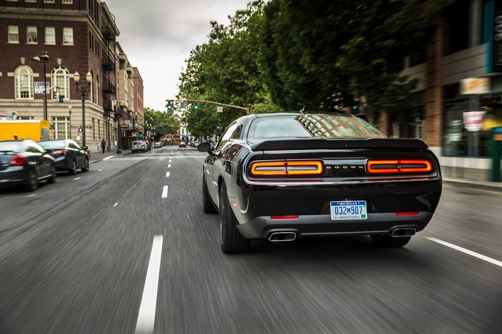 A black Dodge Challenger shows off its aggressive muscle car styling on a city street. 