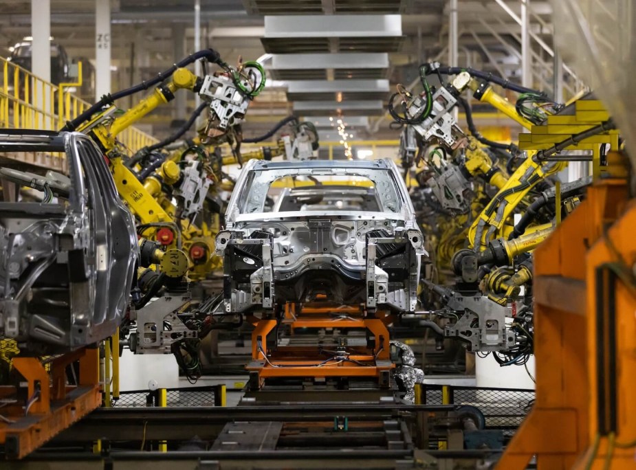 Head-on view of a Dodge Durango SUV body shell being assembled on Chrysler Corporations Detroit line here in the U.S.A., robot arms visible in the background.