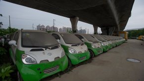 A row of unused electric vehicles (EVs) parked under a bridge in China have lithium-ion battery packs.