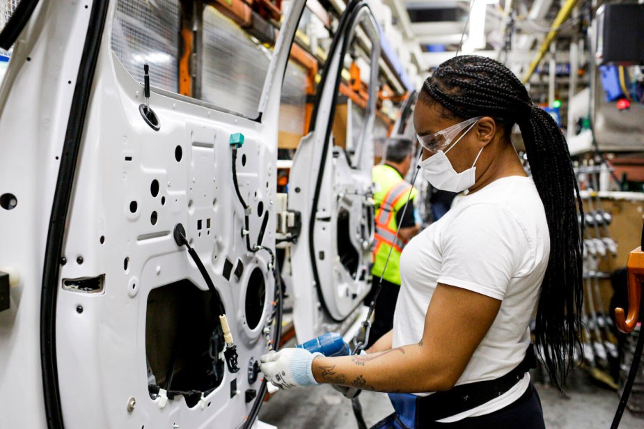 A woman assembles a Ford F-150 full-size half-ton pickup truck door at the Dearborn plant in the U.S.A.