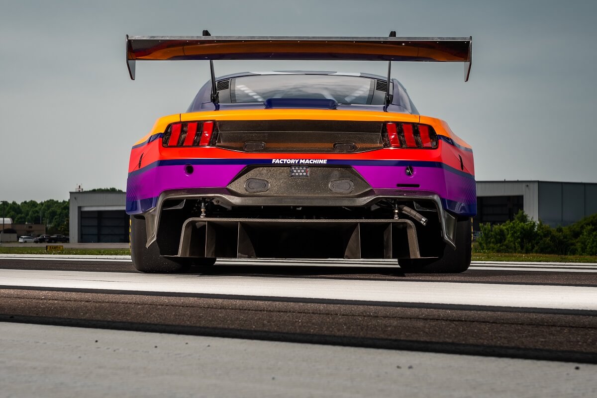 A brightly-colored Ford Mustang GT3 shows off its giant wing.